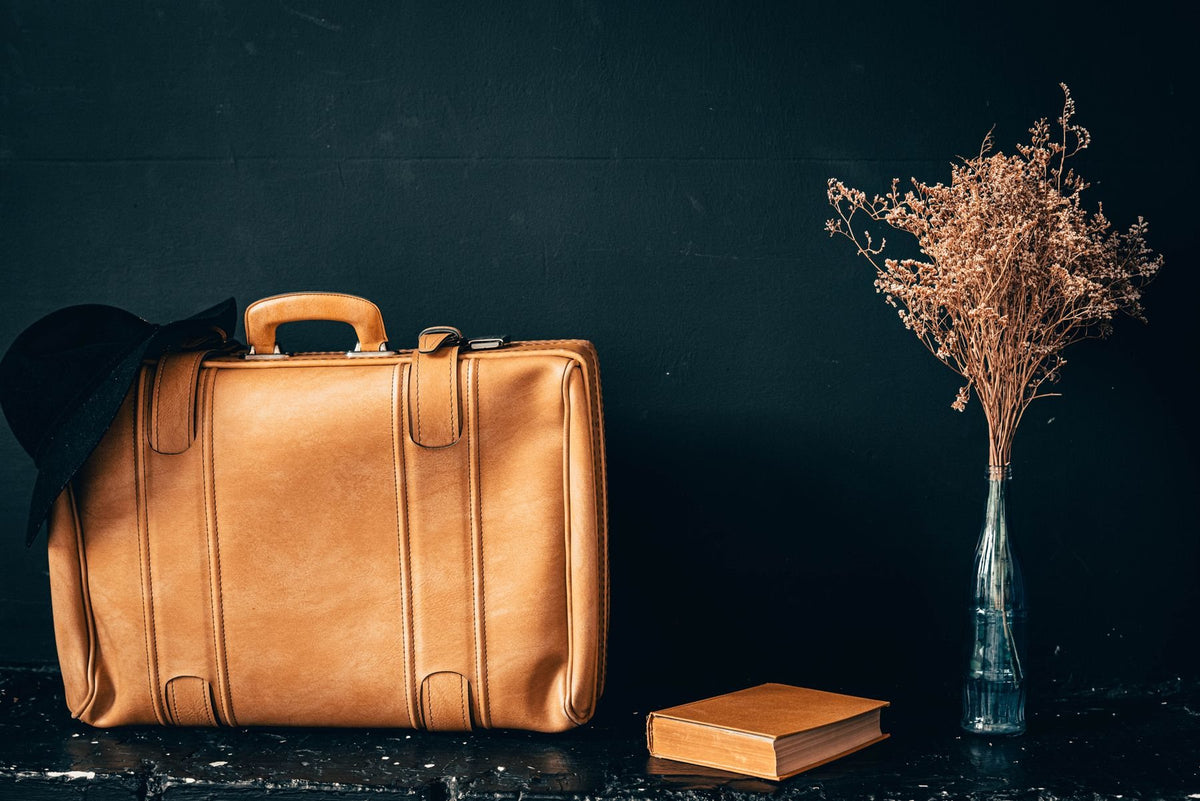 A tan leather suitcase on a dark ground
