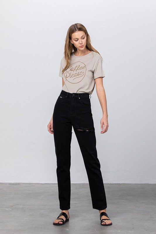 Model wearing high-waist destroyed mom jeans, black non-stretch denim, ripped knee, size 3, inseam 29in, USA-designed.